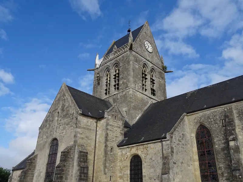 Church of Sainte-Mère-Église with a paratrooper mannequin and parachute on its tower