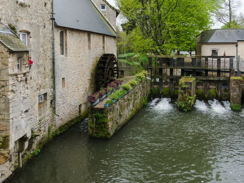 Old stone watermill and wheel on the Aure river in central Bayeux