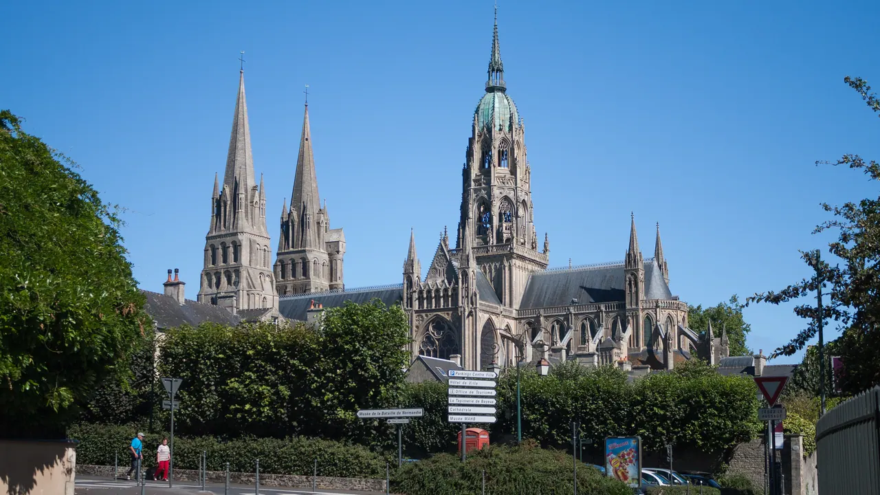 Bayeux Cathedral with its spires and central tower seen from a nearby street
