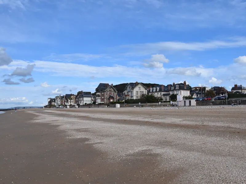 Houlgate beach with sand, sea and seafront villas under a blue sky