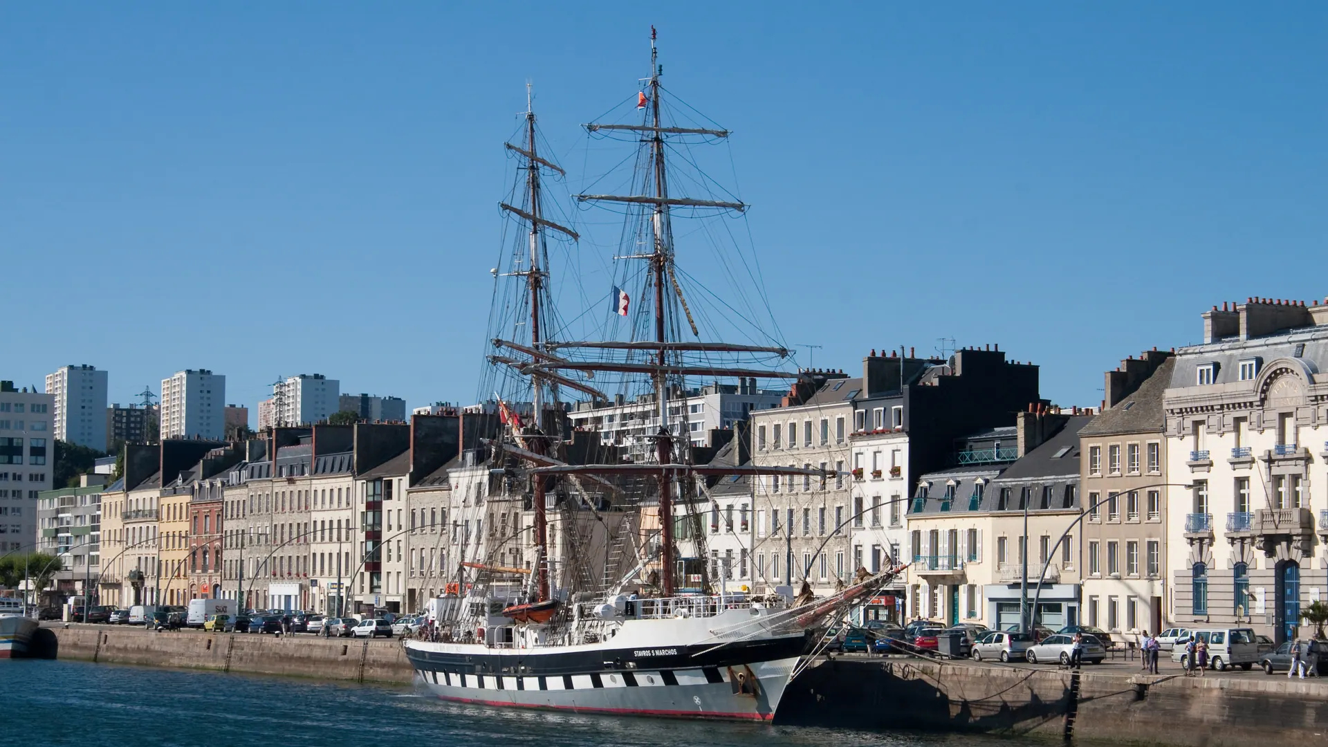 Tall ship moored in Cherbourg harbour in front of the quayside buildings
