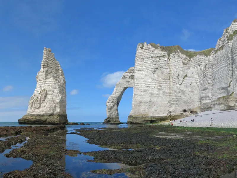 The Aiguille rock needle and Porte d'Aval arch seen from the shore at low tide