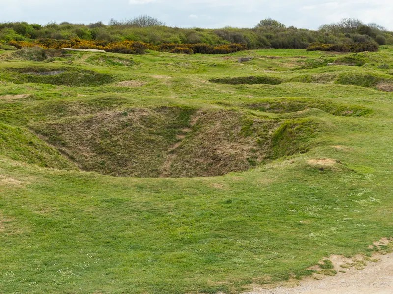 Grass-covered bomb craters left by the 1944 bombardment at Pointe du Hoc