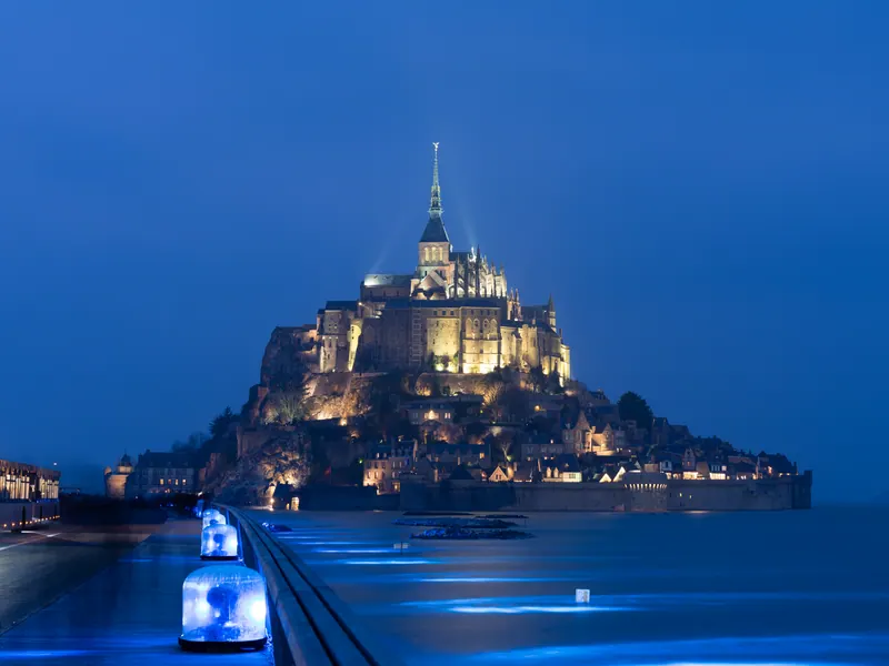 Mont-Saint-Michel lit at dusk, surrounded by water during the March 2015 spring tide